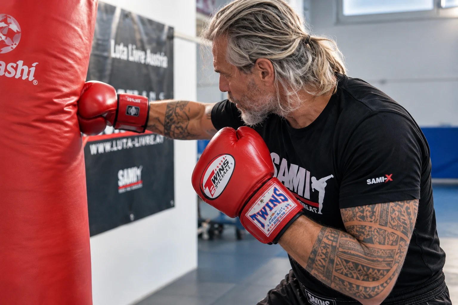 Peter Weckauf trainiert mit roten Boxhandschuhen am Sandsack